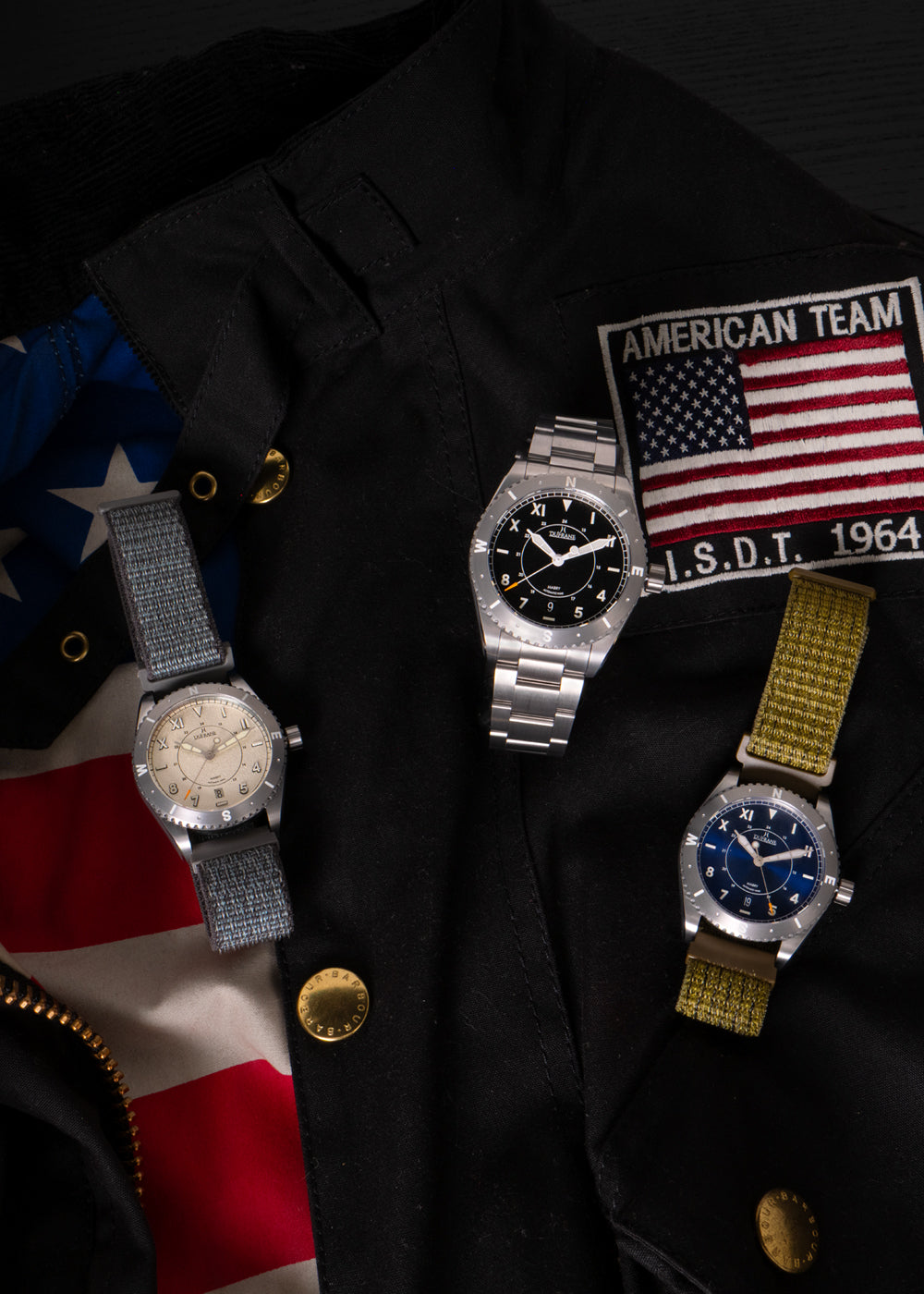 Three watches on a dark surface with an American flag and 'American Team' patch.