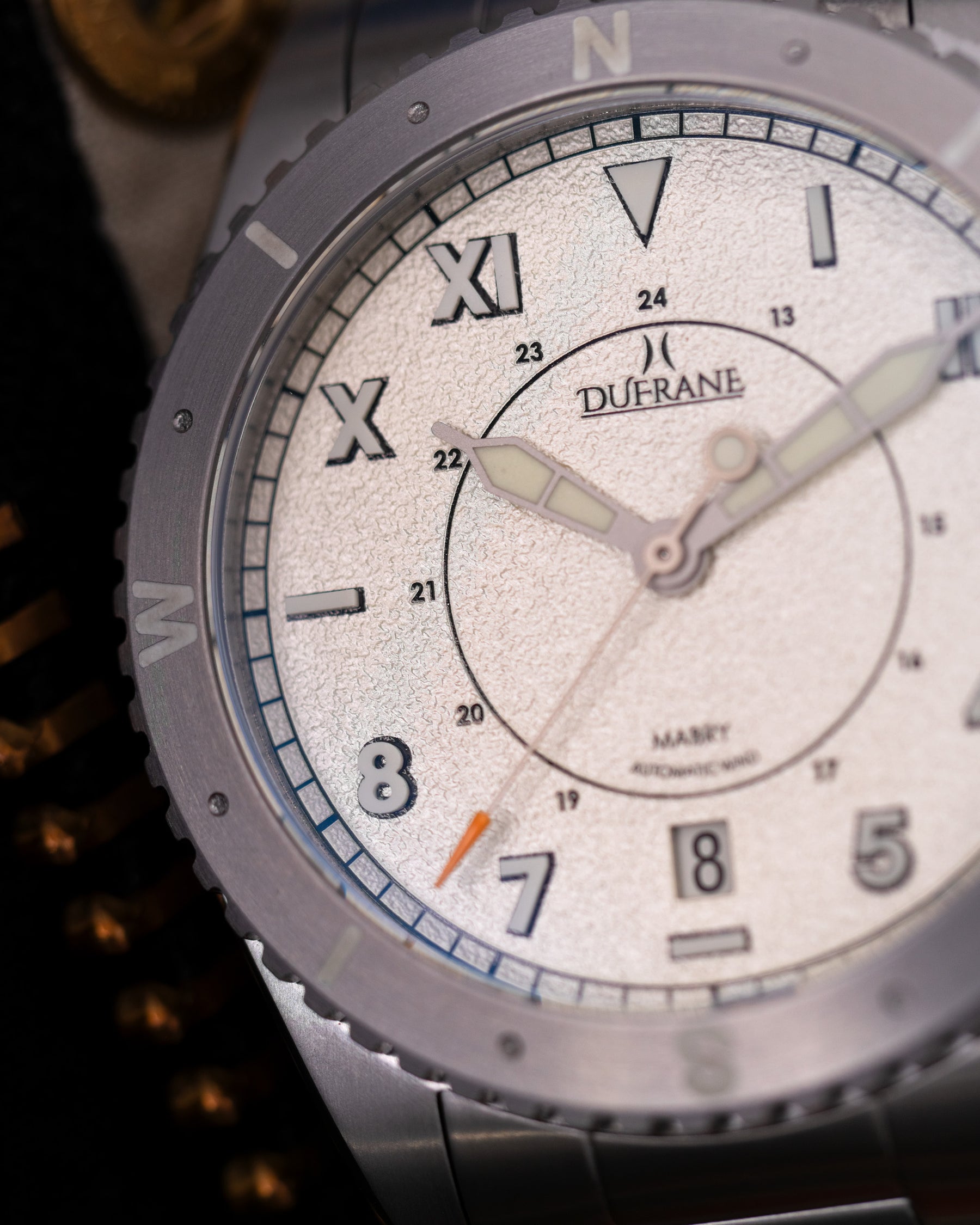 Close-up of a Dufrane watch with a white face and silver case.